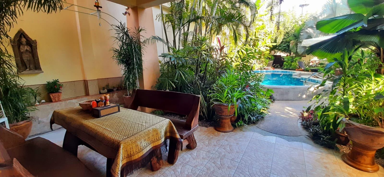 Ground floor covered terrace with seating and view toward the pool